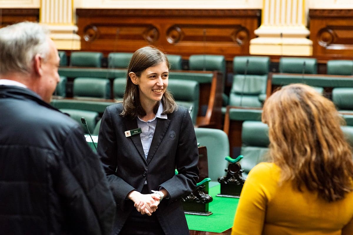 A tour guide conducting a tour of Parliament House with visitors.